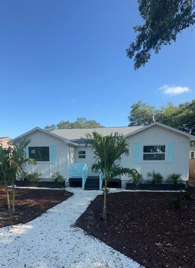 C.A.L.I. Place, a renovated transitional home with palm trees and a white stone walkway