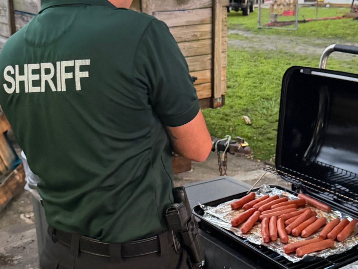 Local sheriff deputy grilling hot dogs at a teen cookout